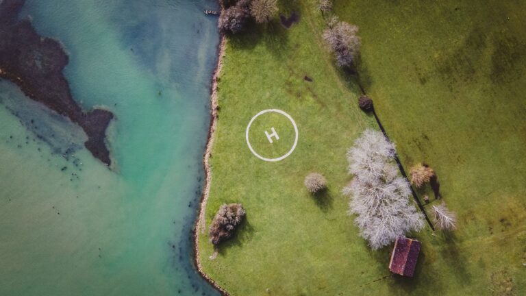 Winter aerial of the riverside lawn, showing the helicopter landing circle, bare trees and the boathouse roof, Pinkmead Estate