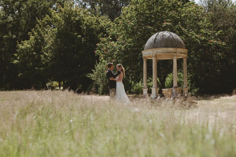 A couple in the long meadow grass beside the domed stone temple at the edge of the woods, Pinkmead Estate