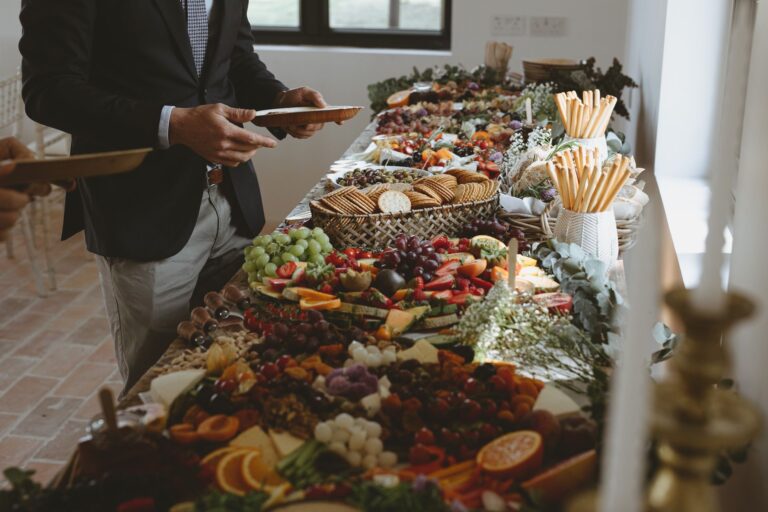 A long grazing table of fruit, cheese, breads and charcuterie laid along a window, Pinkmead Estate