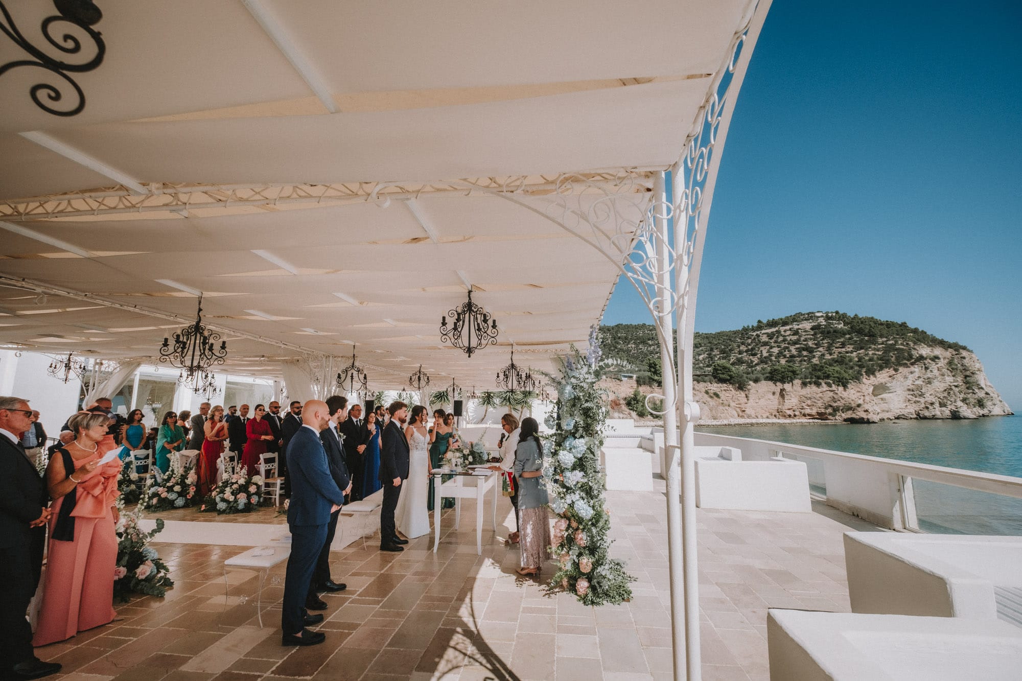 Guests stand for the bride at the clifftop ceremony at La Casa e il Mare, Mattinata, on the Gargano coast, Pino Coduti Photography