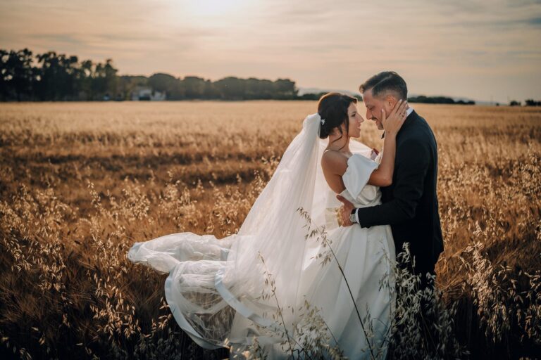 A couple close together in a ripe wheat field at golden hour, province of Foggia, Pino Coduti Photography