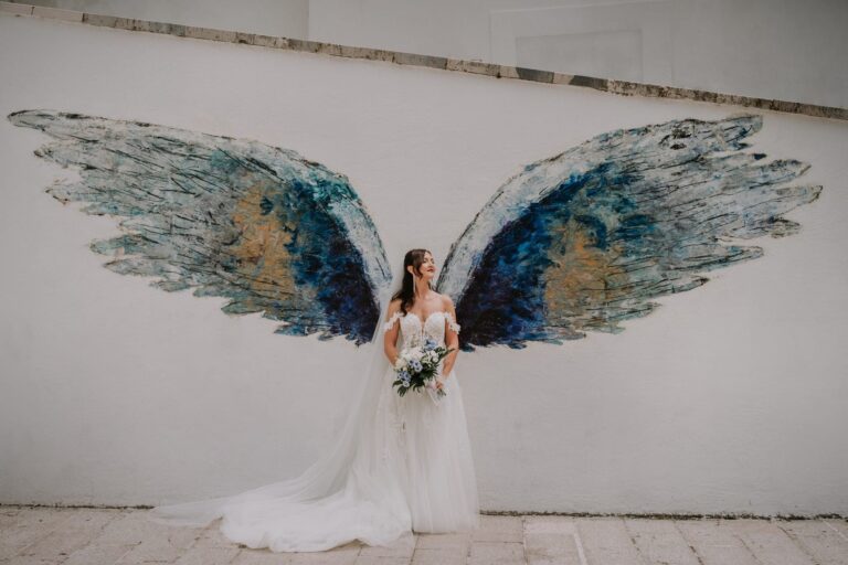 A bride before a painted pair of angel wings on a wall in Monte Sant'Angelo, Pino Coduti Photography