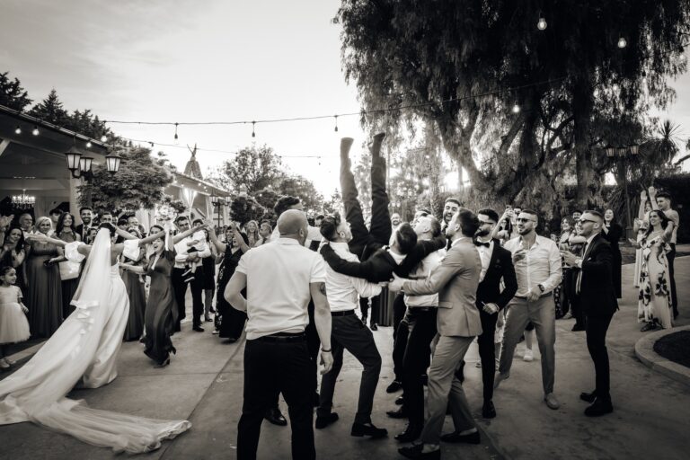Guests throw the groom into the air at the reception, black and white, Pino Coduti Photography