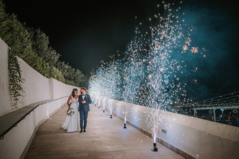 Bride and groom walk between sparkler fountains at La Locanda del Carrubo, Mattinata, Pino Coduti Photography