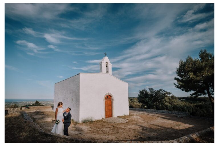 Matteo and Federica beside a small white chapel on their Alberobello wedding day, Pino Coduti Photography