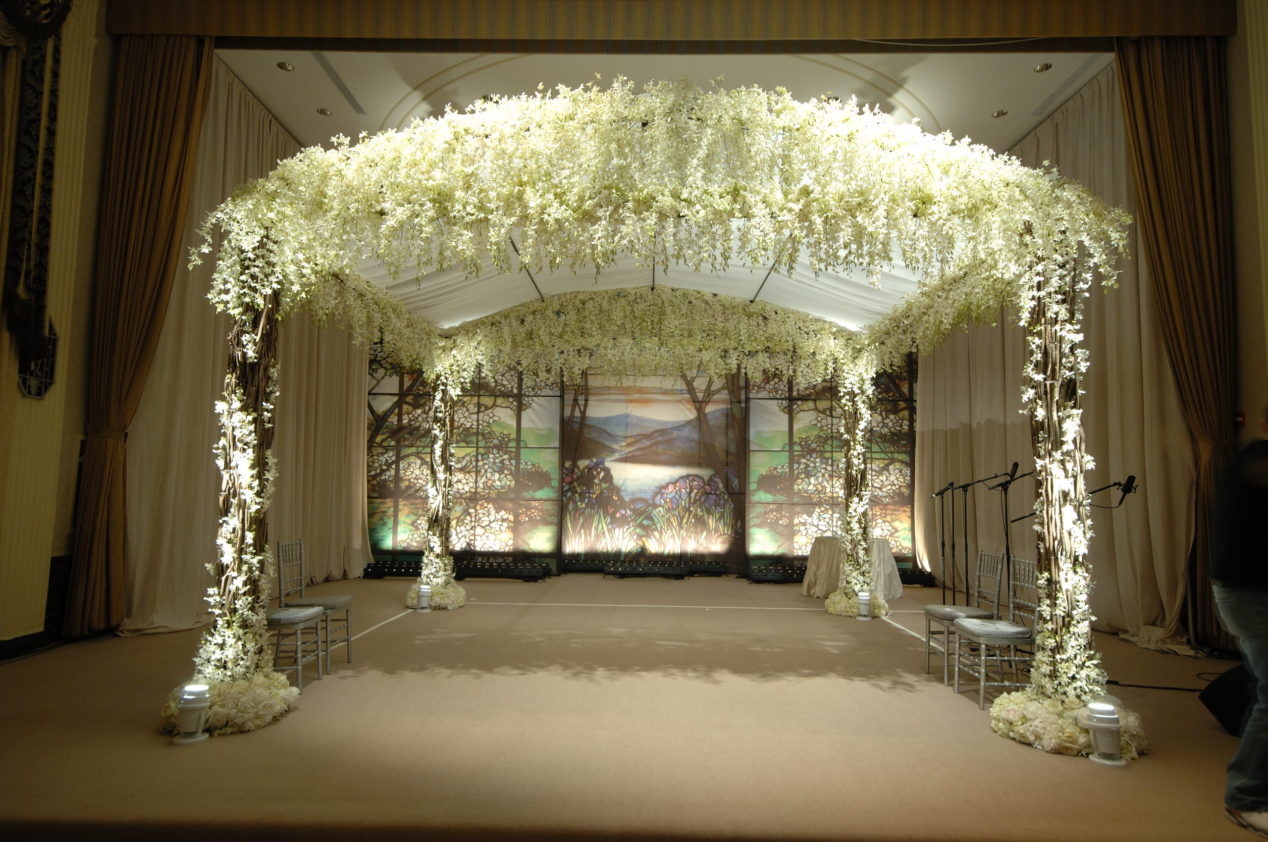 A canopy of white flowers over a ceremony stage in a ballroom, Preston Bailey