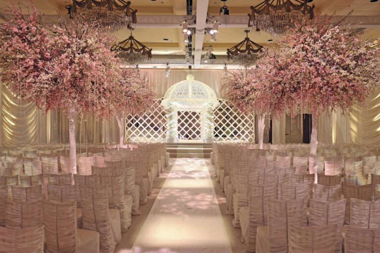 A ceremony aisle between two blossoming trees leading to a white gazebo, Preston Bailey