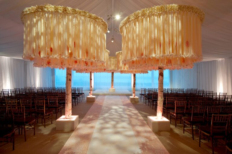 Two hanging floral canopies over a waterside ceremony aisle with the sea behind, Preston Bailey