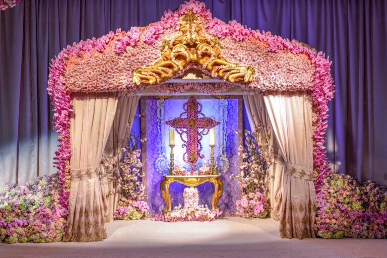 An ornate floral and gilded ceremony canopy with rose-covered columns and drapes, Preston Bailey