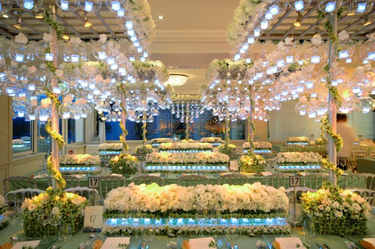 A ballroom reception with hanging floral chandeliers and low floral table runners, Preston Bailey