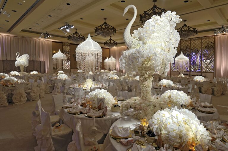 Reception tables with a sculpted white orchid swan centrepiece in a ballroom, Preston Bailey