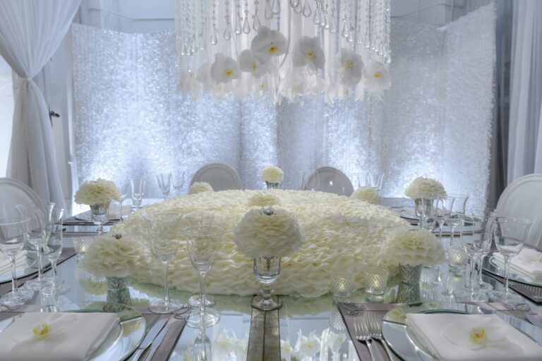 A round table covered in white flowers beneath a chandelier of hanging blooms, Preston Bailey