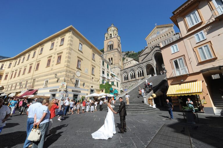 Crossing the piazza at Amalfi, the striped front of the Duomo above her, Ramona Avitabile Wedding Planner