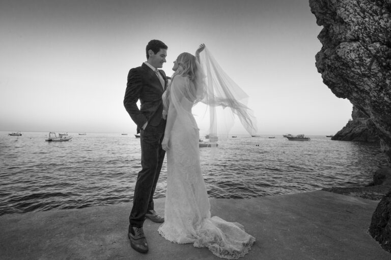 Below the cliff face, in black and white, the fishing boats offshore, Ramona Avitabile Wedding Planner