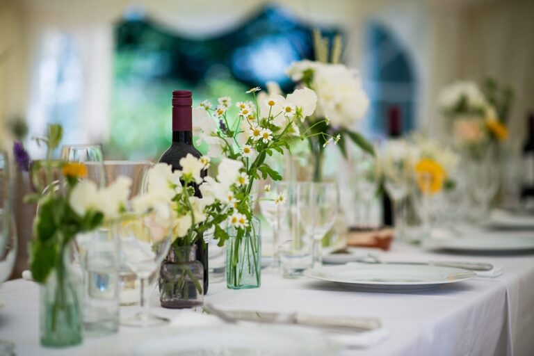 A long wedding table dressed with wildflowers in bottles, Rebecca Mays