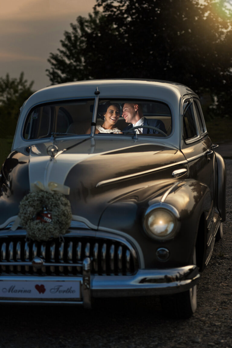 Couple in a vintage wedding car at golden hour, Reflexion Studio