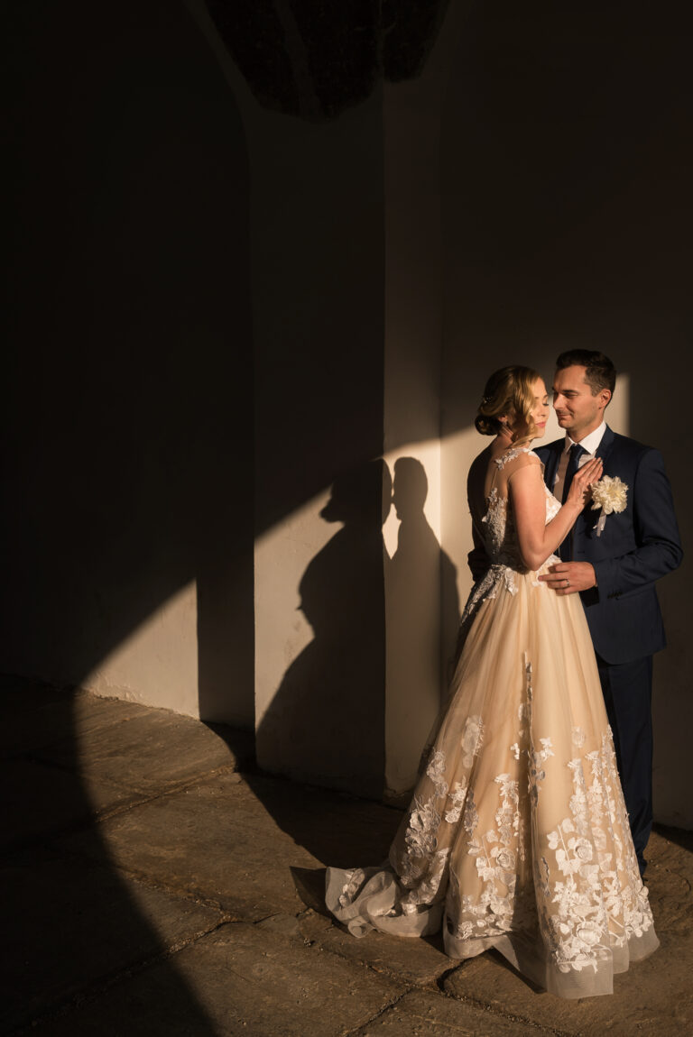 Couple in a shaft of evening light beneath a colonnade, Reflexion Studio
