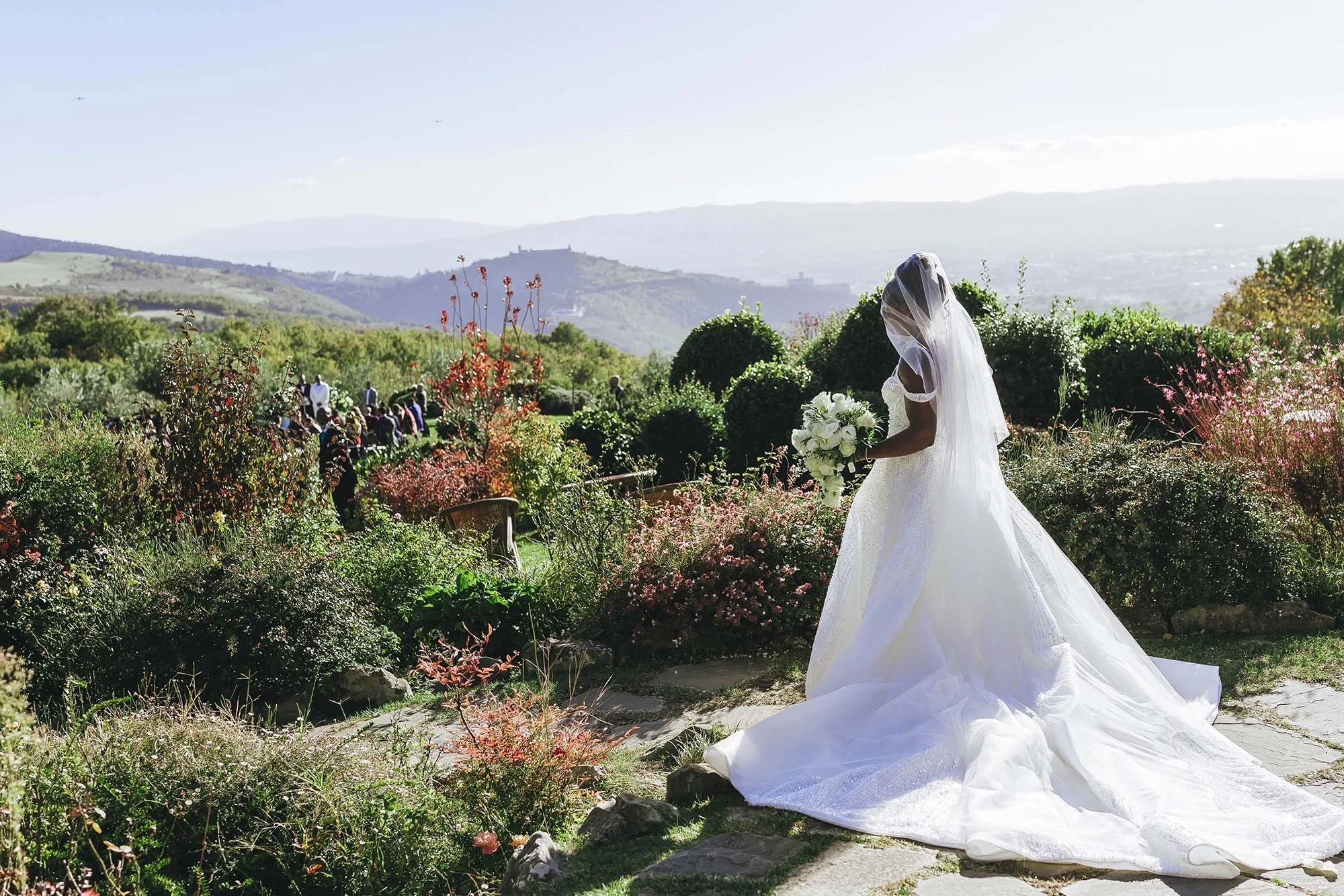 A bride on her way to a garden ceremony at Castello di Petrata near Assisi, Umbria, Rellini Art Studio