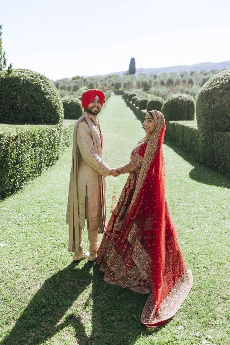 An Indian bride and groom between clipped hedges at Torre a Cona near Florence, Rellini Art Studio