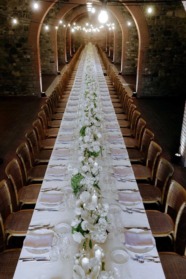 A long dinner table set in the vaulted cellar at Villa la Selva, Tuscany, Rellini Art Studio