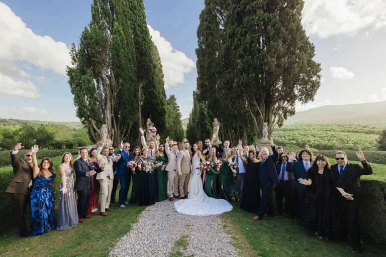 The whole wedding party between the cypresses after the ceremony at Borgo Stomennano, Tuscany, Rellini Art Studio