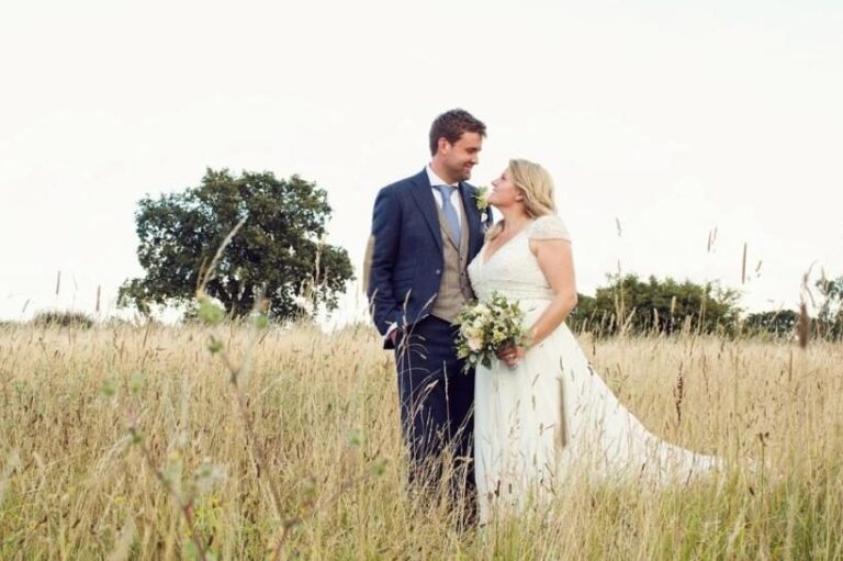 The bride and groom in the wildflower meadow, framed by a lone oak in the 35-acre grounds, Retreat East