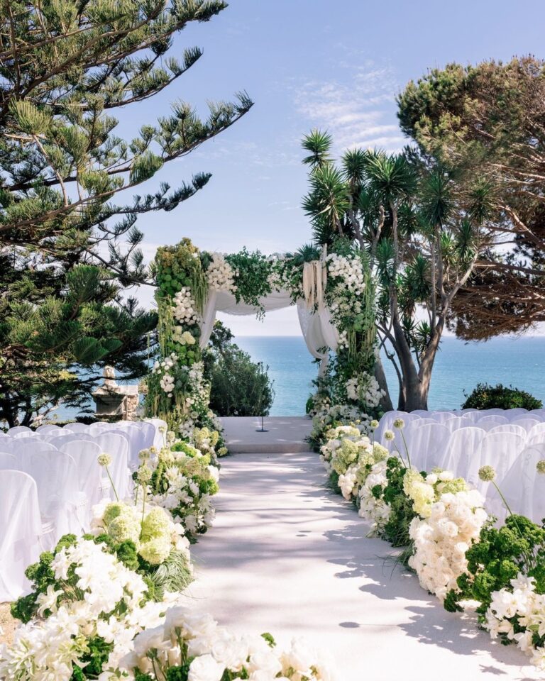 Ceremony aisle lined with white florals toward the Pacific, Malibu, Revelry Event Designers