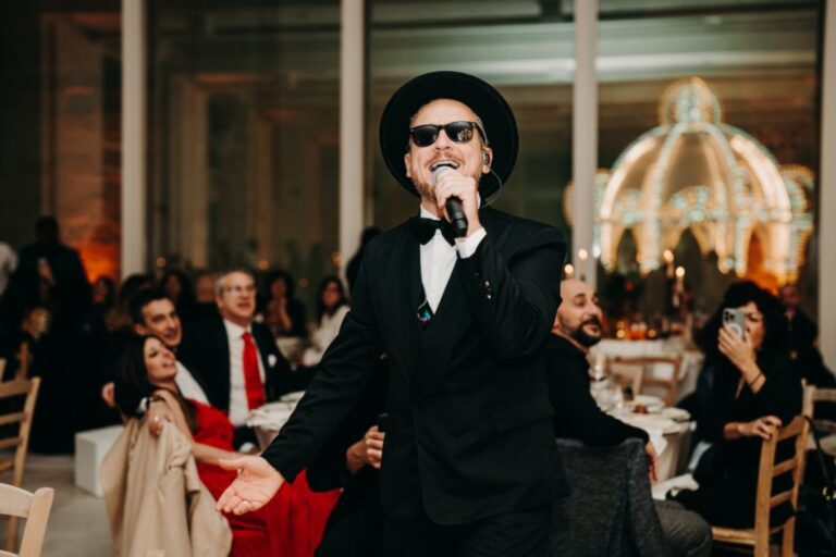 Vocalist in a black hat and bow tie performing among the guests, Rinaldi Production