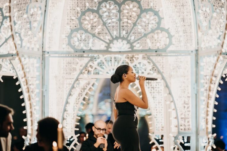 Soloist singing inside a white illuminated arch stage, Rinaldi Production