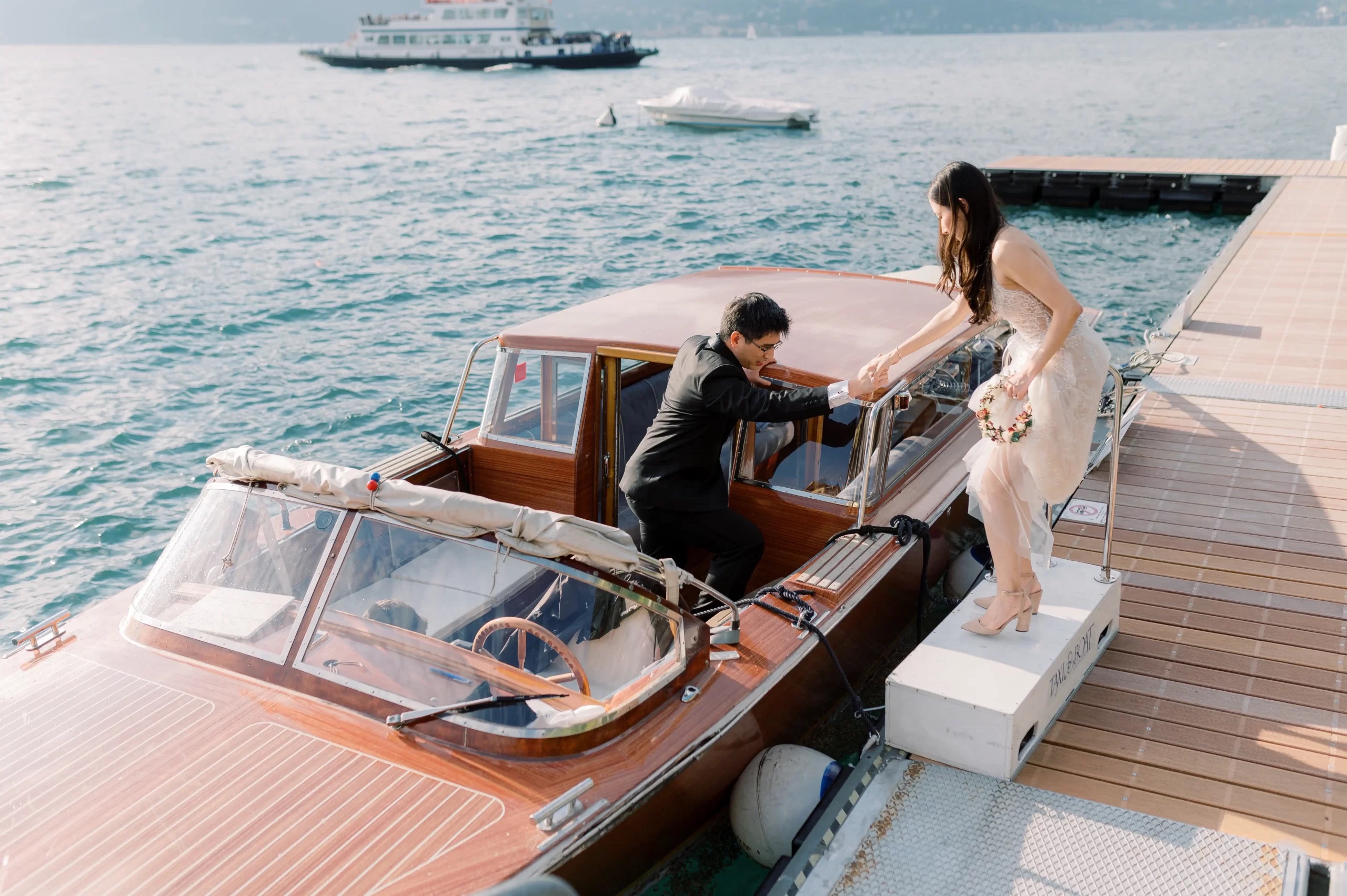 Stepping aboard a wooden boat at the jetty on Lake Como, Rocco Daniele Photography