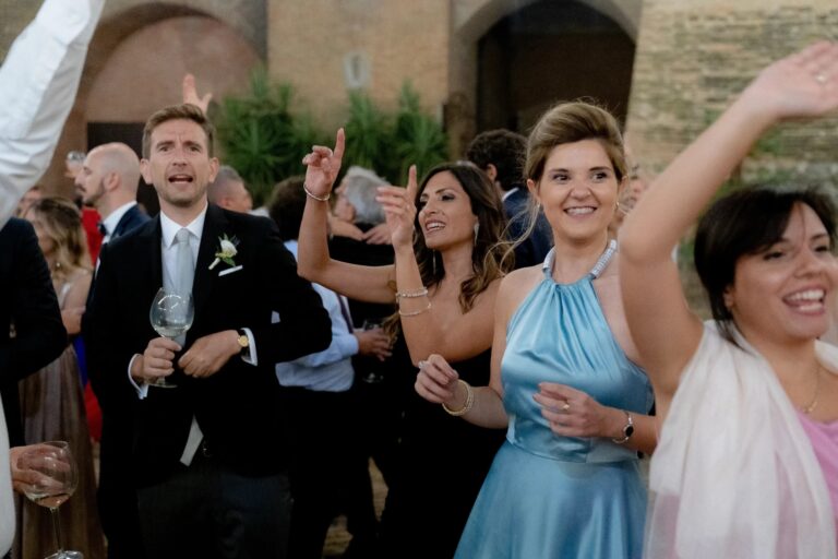 Guests singing and dancing in the courtyard at night, Castello San Basilio, Matera, Rocco Daniele Photography