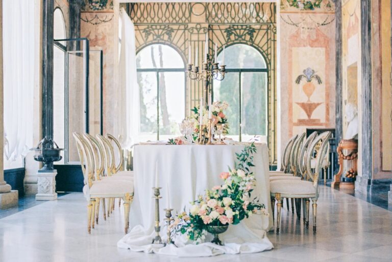 The frescoed hall set for dinner, with flowers and gilded chairs, Torre di Pila, Umbria, Rocco Daniele Photography