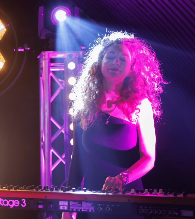 The keyboard player at work under purple stage light, Rocks The Room