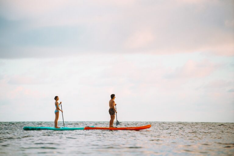 Stand-up paddleboarding on the calm water off the resort beach, Rocky’s Boutique Resort