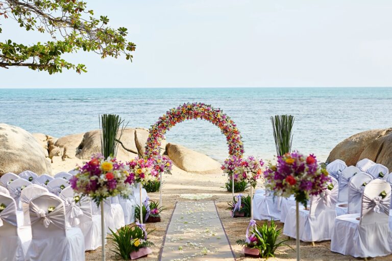 Ceremony aisle with a floral arch and arrangements on the sand, Rocky’s Boutique Resort