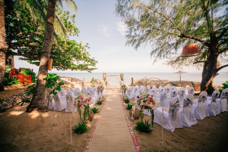 A ceremony set-up under the trees with the aisle running to the shore, Rocky’s Boutique Resort