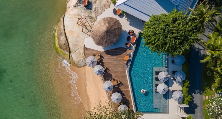 Aerial view of the beachfront pool, sun deck and granite rocks at the water's edge, Rocky’s Boutique Resort
