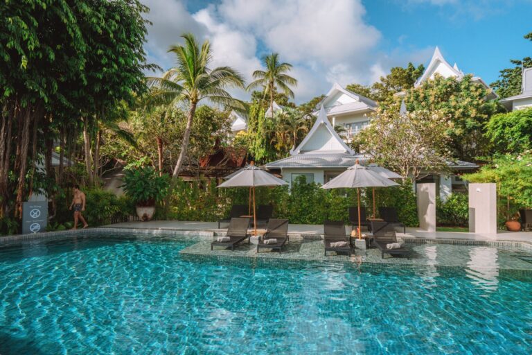 The garden pool with palms and the white pavilion roofs behind, Rocky’s Boutique Resort