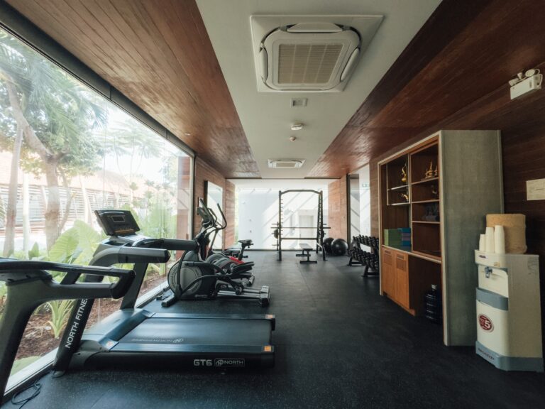 Fitness room with cardio equipment and sea-facing windows, Rocky’s Boutique Resort