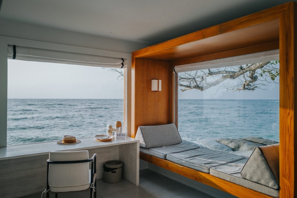 A window seat in a room looking out to the sea
