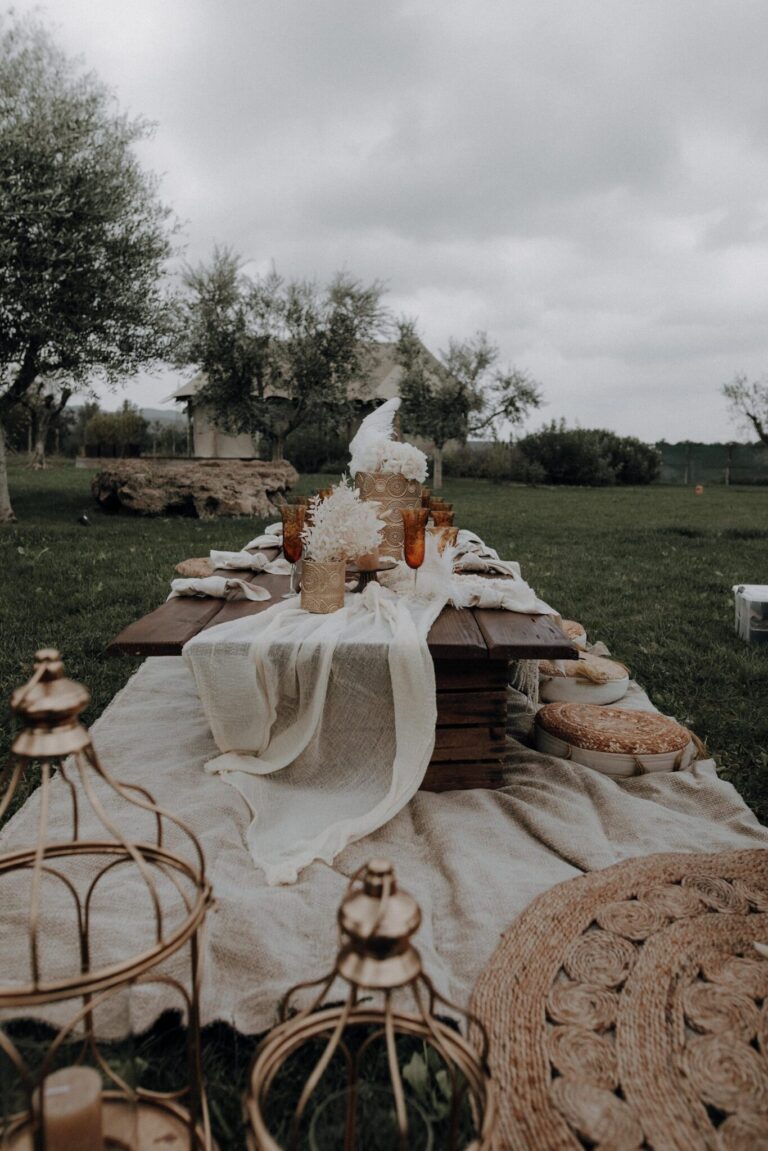An outdoor table on rugs with lanterns and dried flowers among olive trees, Terme di Vulci (Sara & Luca), RoRas Destination Wedding