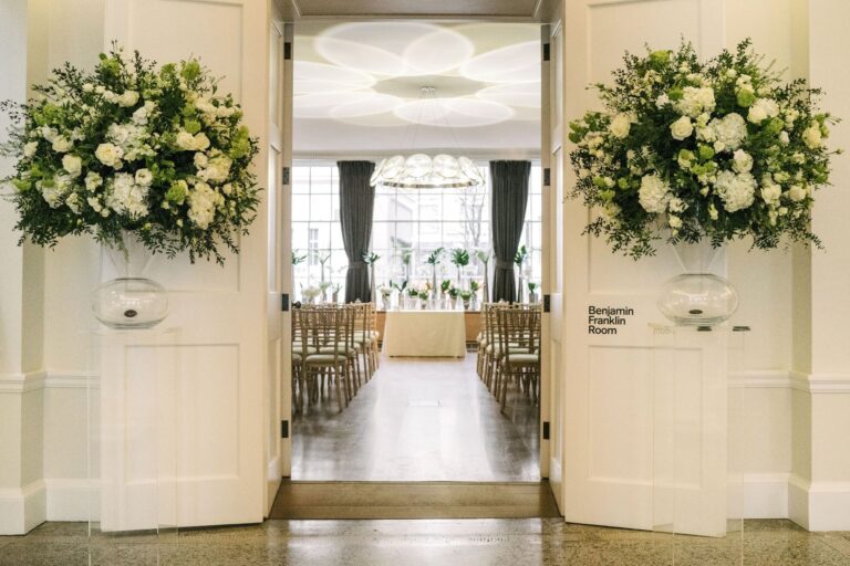 Double doors opening onto a ceremony set with floral arrangements, RSA House