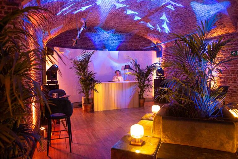 A DJ booth among palms in the Vaults, RSA House