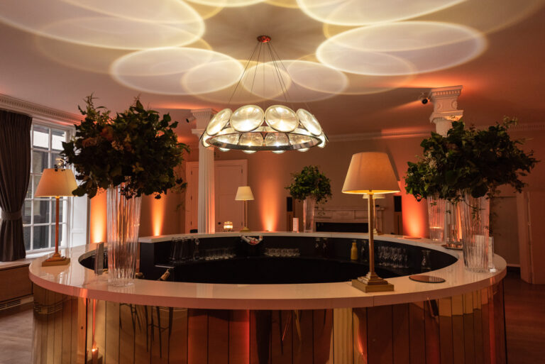 A circular bar beneath a petal shaped ceiling light, RSA House