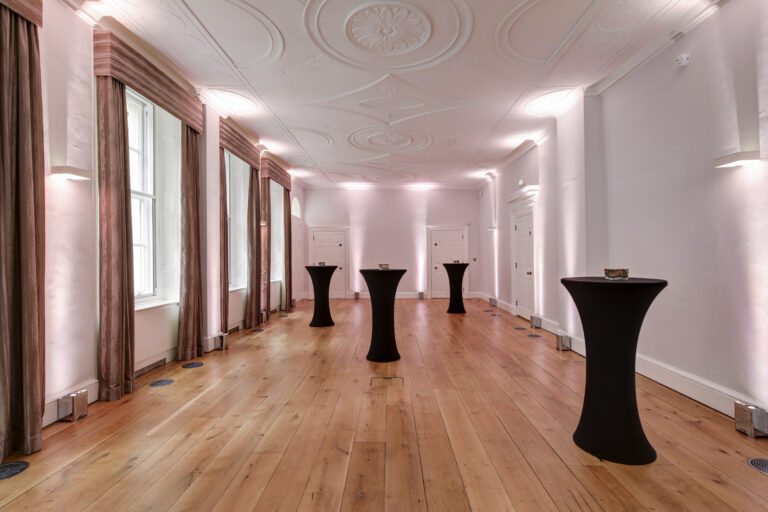 A reception room with cocktail tables and a plaster cornice, RSA House