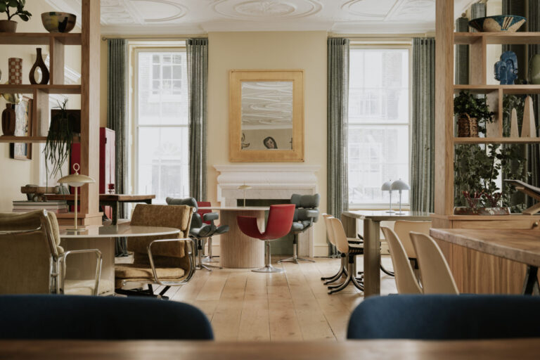 A lounge with armchairs between tall windows, RSA House
