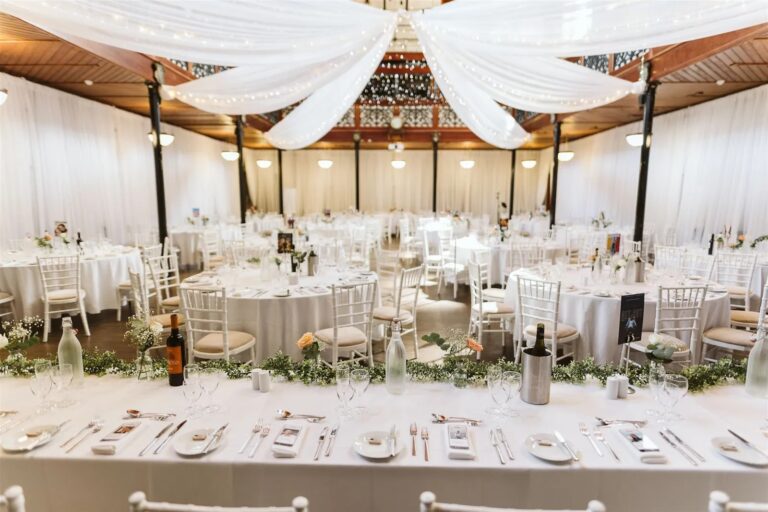 Round tables set for a wedding breakfast beneath draped fabric, Salomons Estate