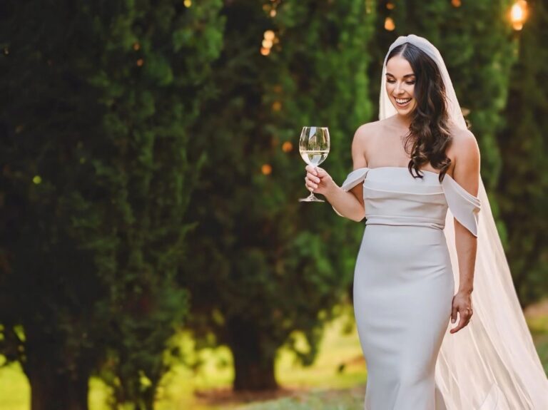 Bride with a glass of wine under the evening light, soft waves and natural make-up, Samantha Pretto