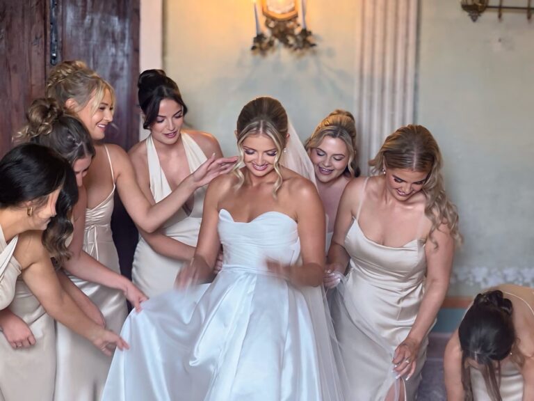 Bridesmaids helping the bride into her gown, hair and make-up complete, Samantha Pretto