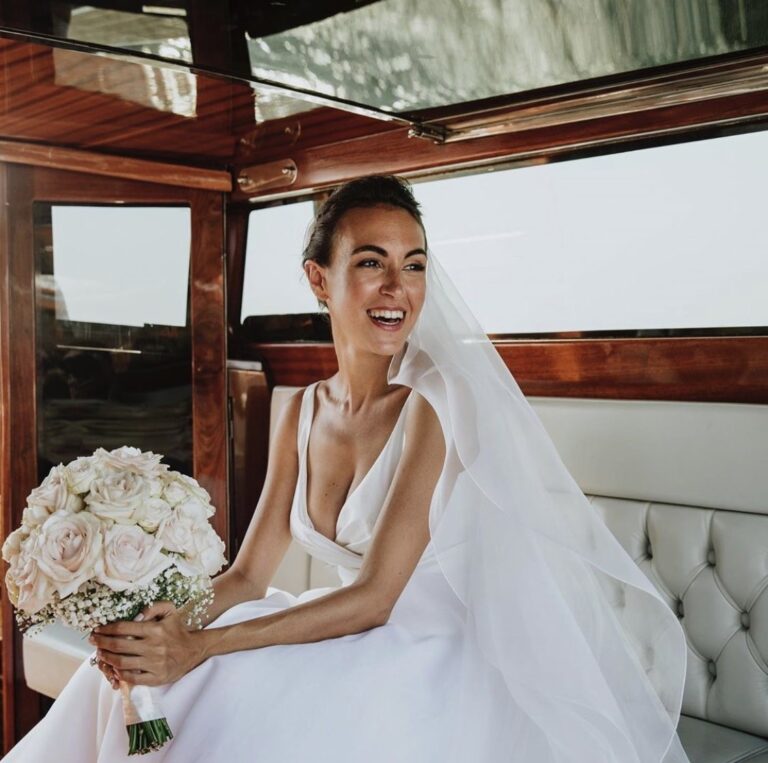Bride laughing in the cabin of a classic wooden boat, bouquet of white roses, Samantha Pretto